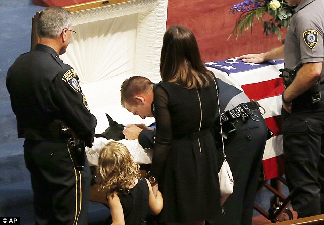 Revered dog: Oklahoma City police officer Ryan Stark leans over the casket of his canine partner, K-9 Kye, following full police funeral services for the dog on Thursday